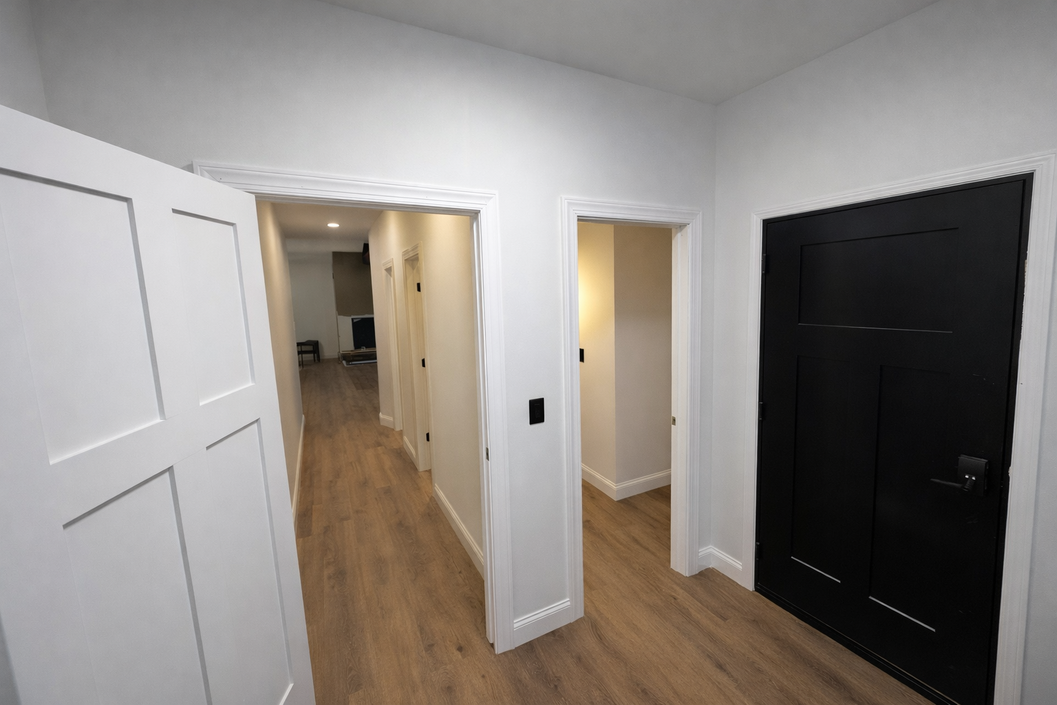 Interior space with two open doorways and black entry door